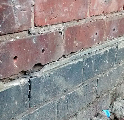 Chemical Damp Proof Course holes in a brick wall, just above the original  slate DPC